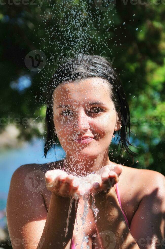 linda mulher lavando e limpando o rosto no chuveiro foto