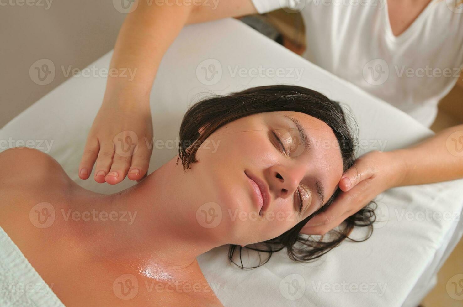 mulher bonita tem massagem no spa e centro de bem-estar foto