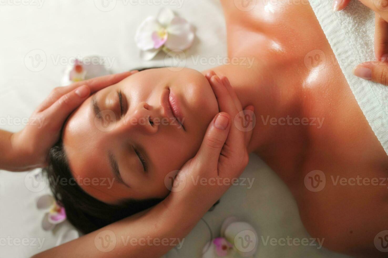 mulher bonita tem massagem no spa e centro de bem-estar foto