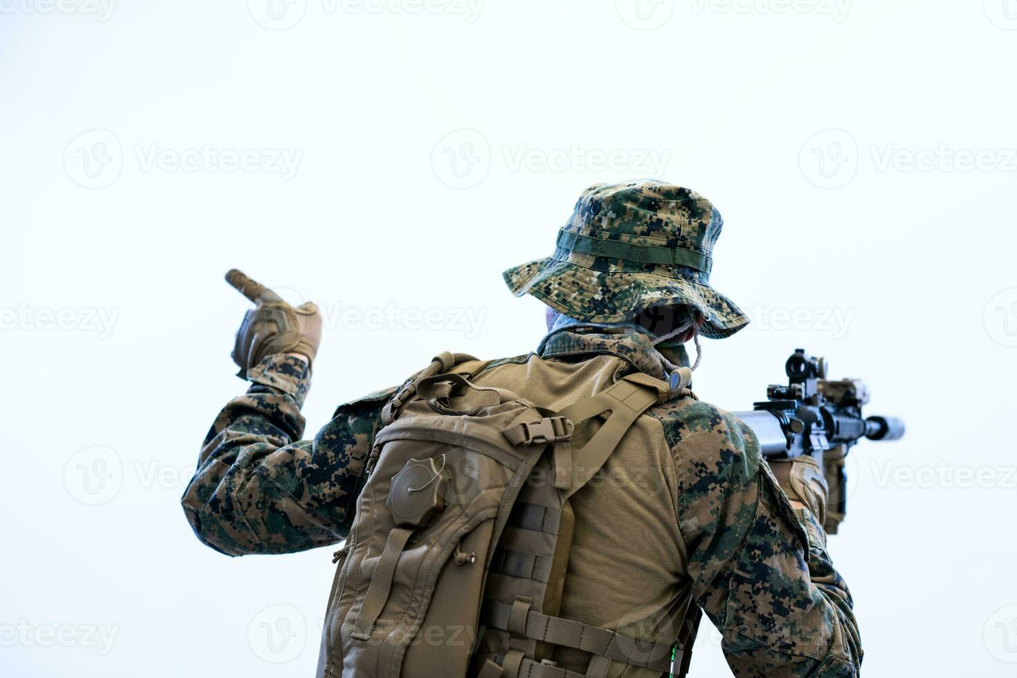 soldado em ação dando comandos à equipe por sinal de mão foto