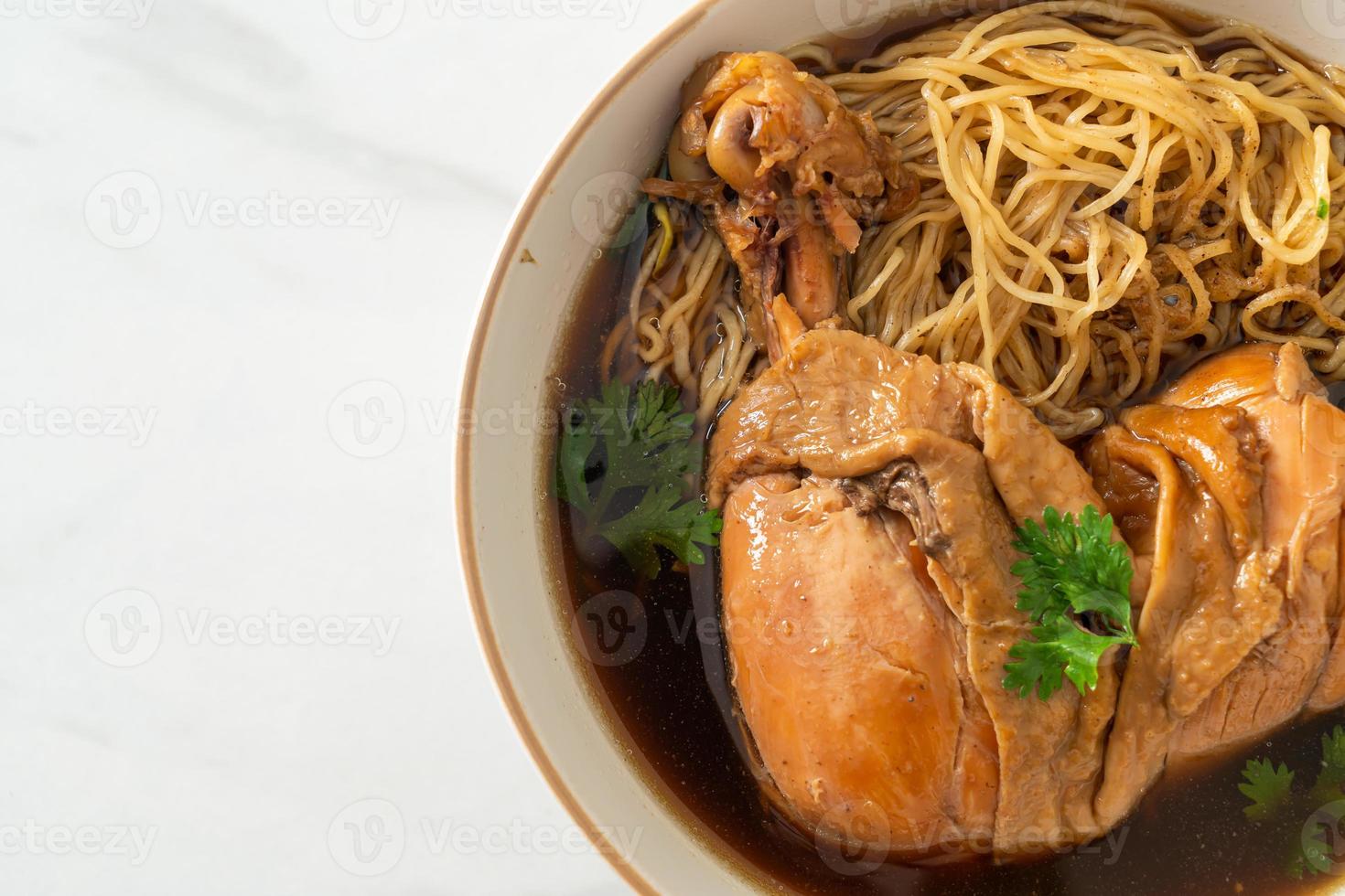 macarrão com frango assado na sopa marrom foto