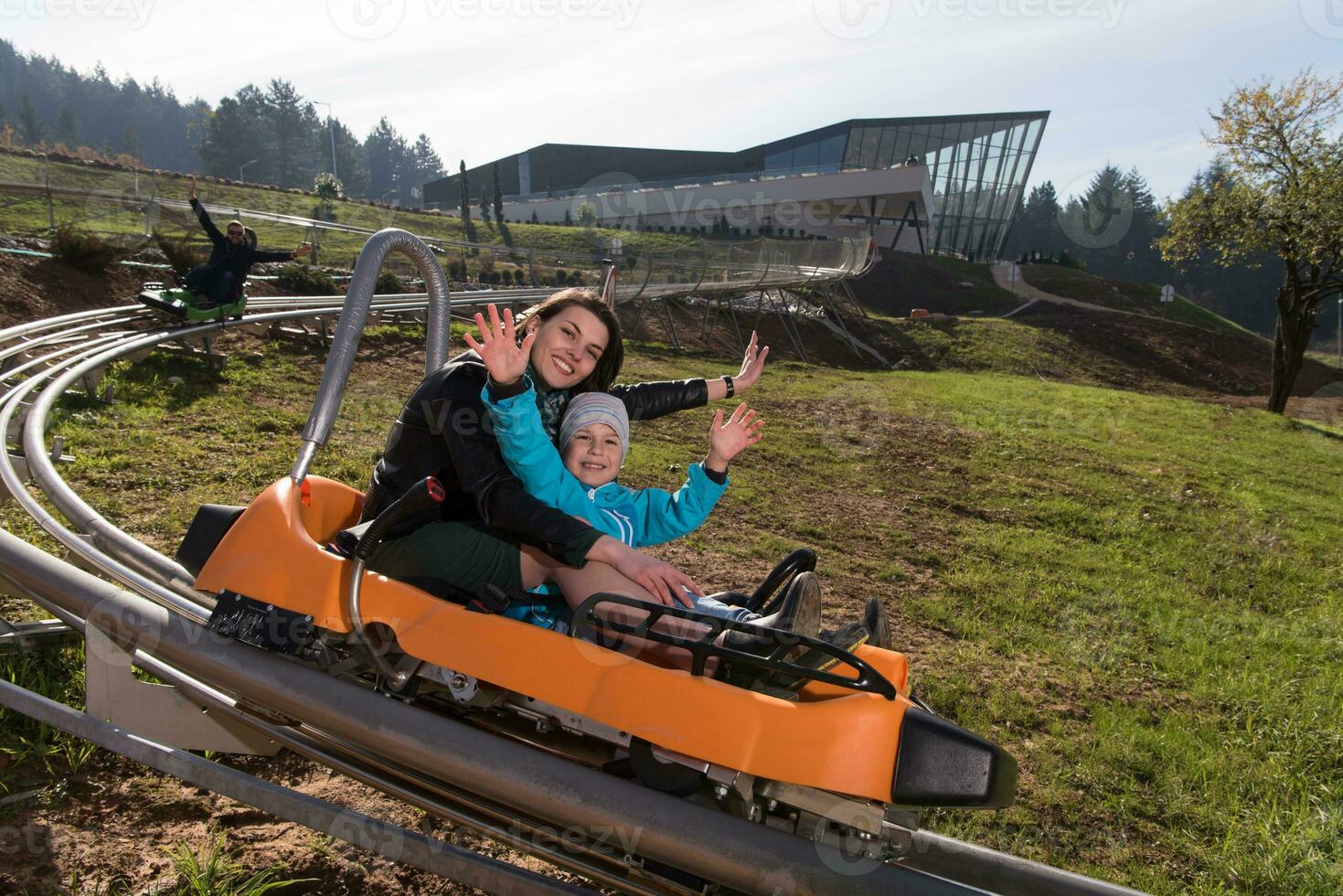 mãe e filho gostam de dirigir na montanha-russa alpina foto