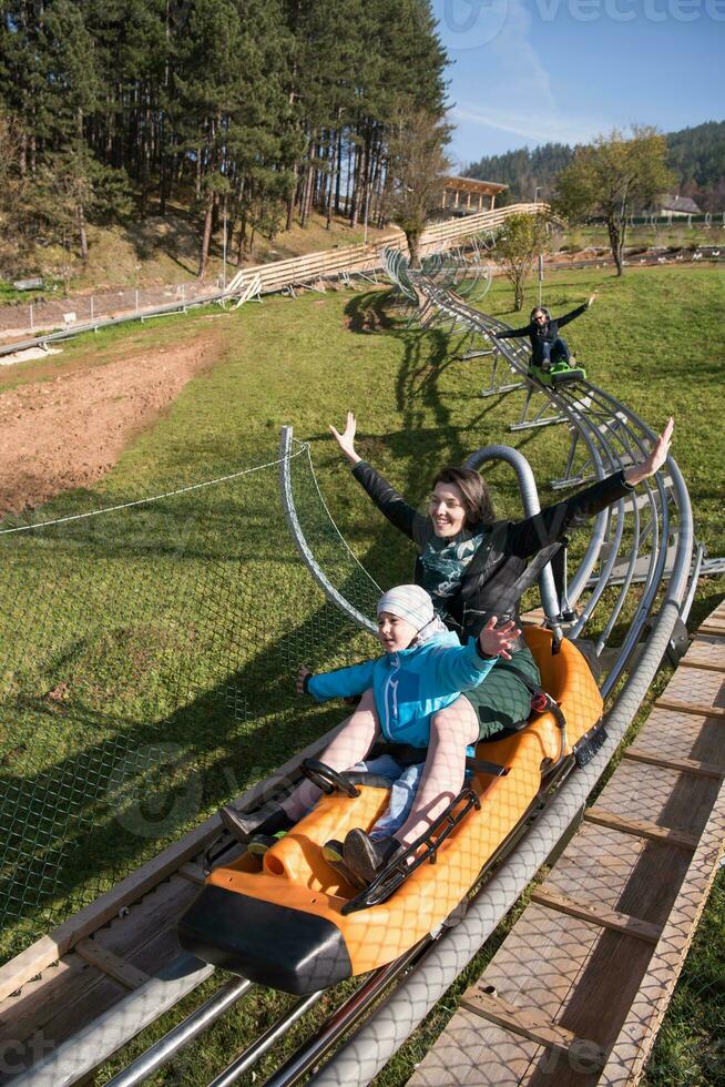 mãe e filho gostam de dirigir na montanha-russa alpina foto