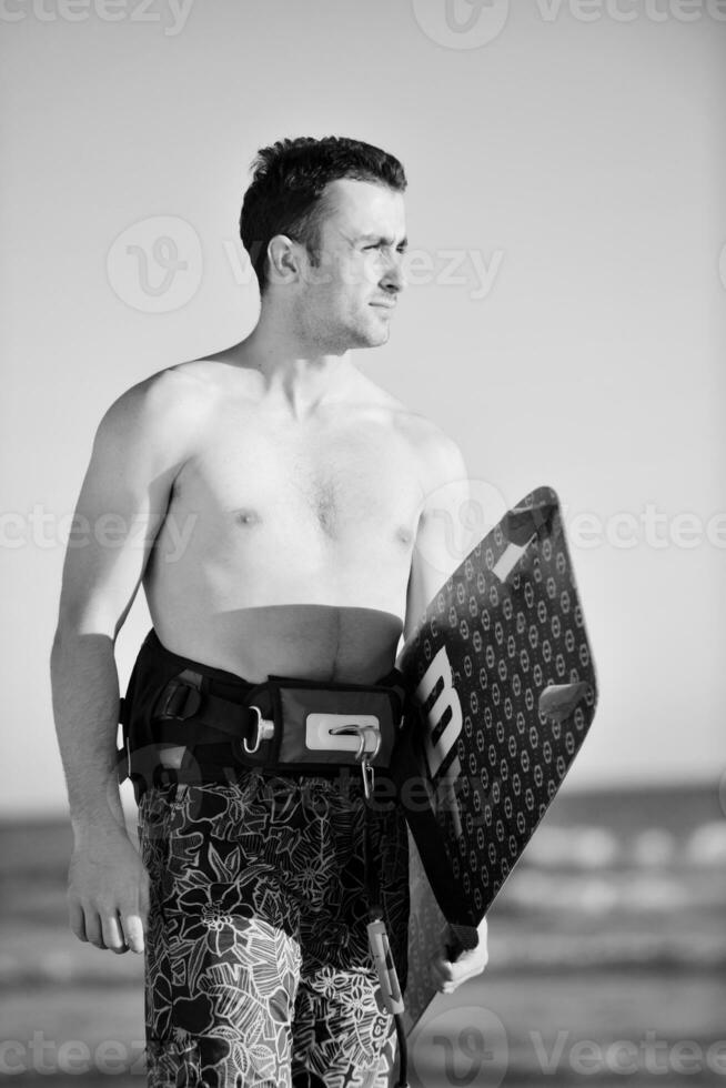 retrato de um jovem kitsurf na praia ao pôr do sol foto