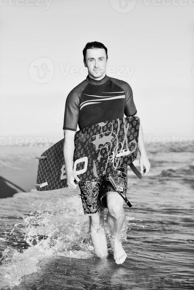 retrato de um jovem kitsurf na praia ao pôr do sol foto