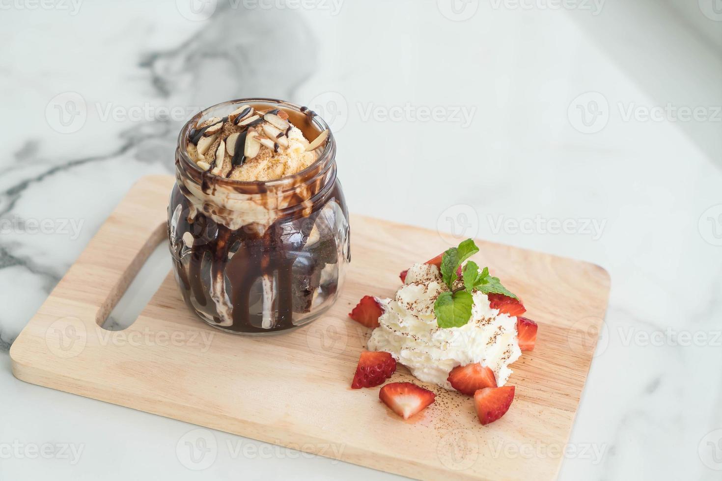 brownies de chocolate com sorvete de baunilha, chantilly e morango foto