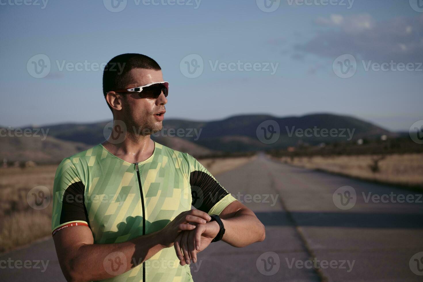 atleta de triatlo descansando e configurando smartwatch foto