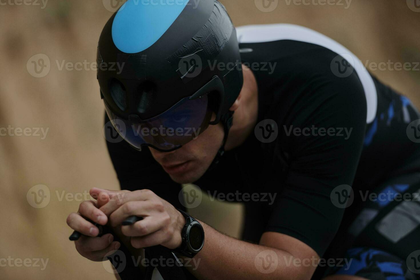 atleta de triatlo andando de bicicleta vestindo preto foto