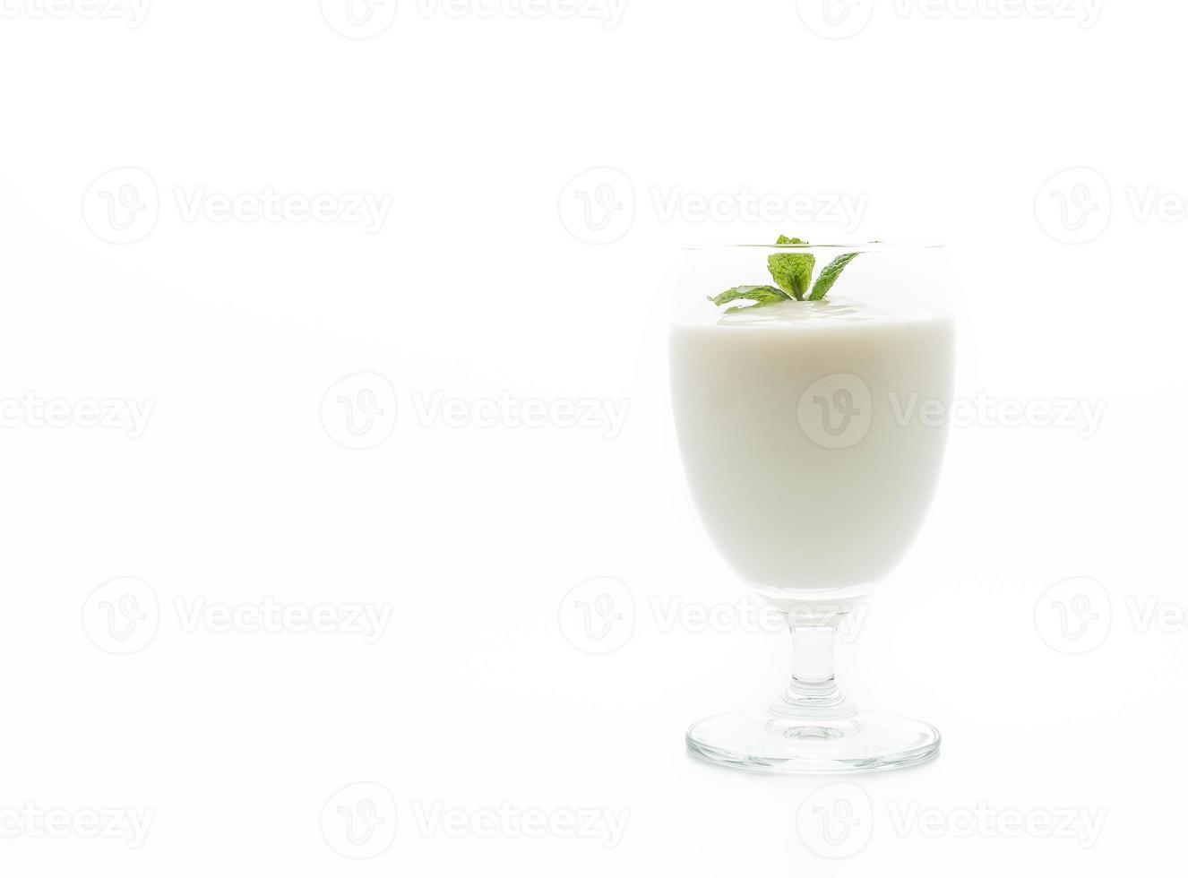um copo de iogurte no fundo branco foto