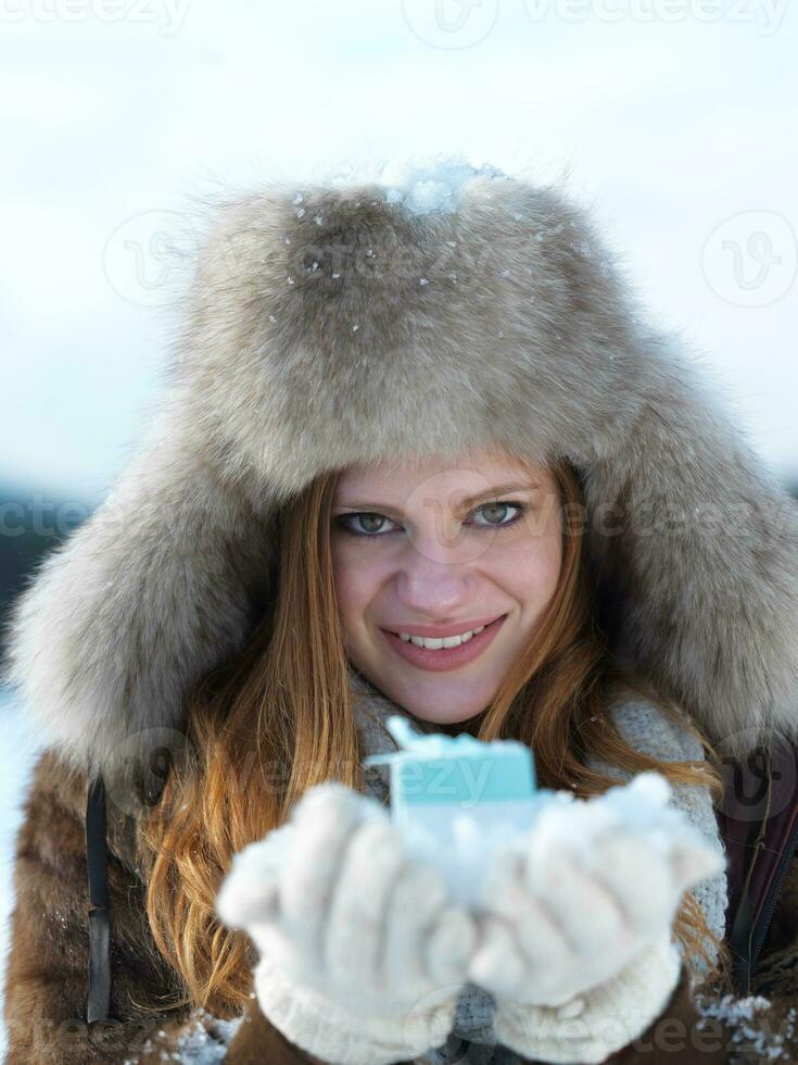 retrato do menina com presente às inverno cena e neve dentro backgrond foto