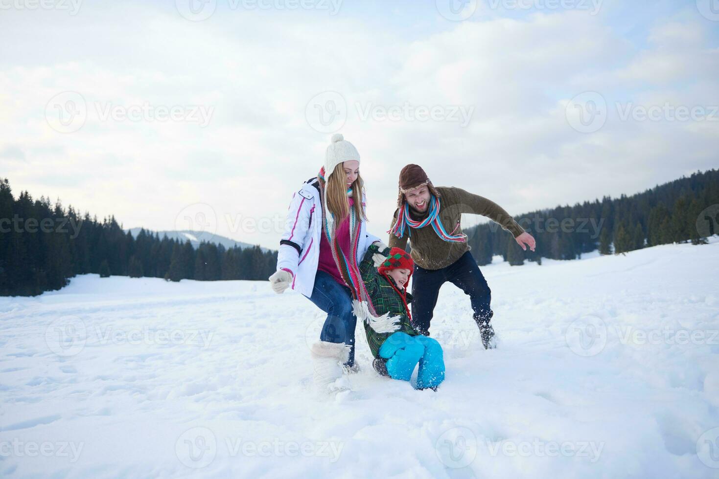 família feliz jogando juntos na neve no inverno foto