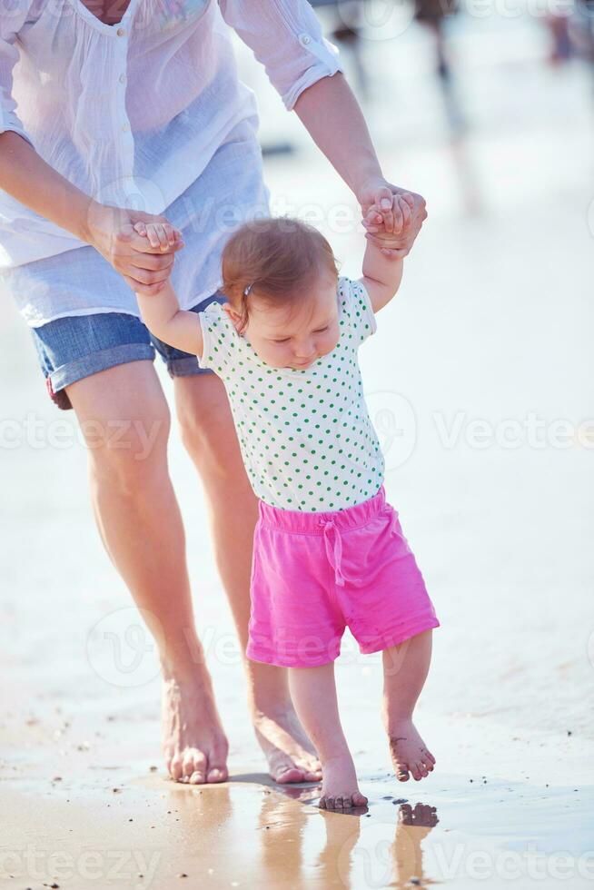 mãe e bebê na praia se divertem foto