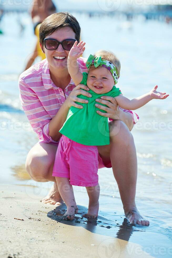 mãe e bebê na praia se divertem foto