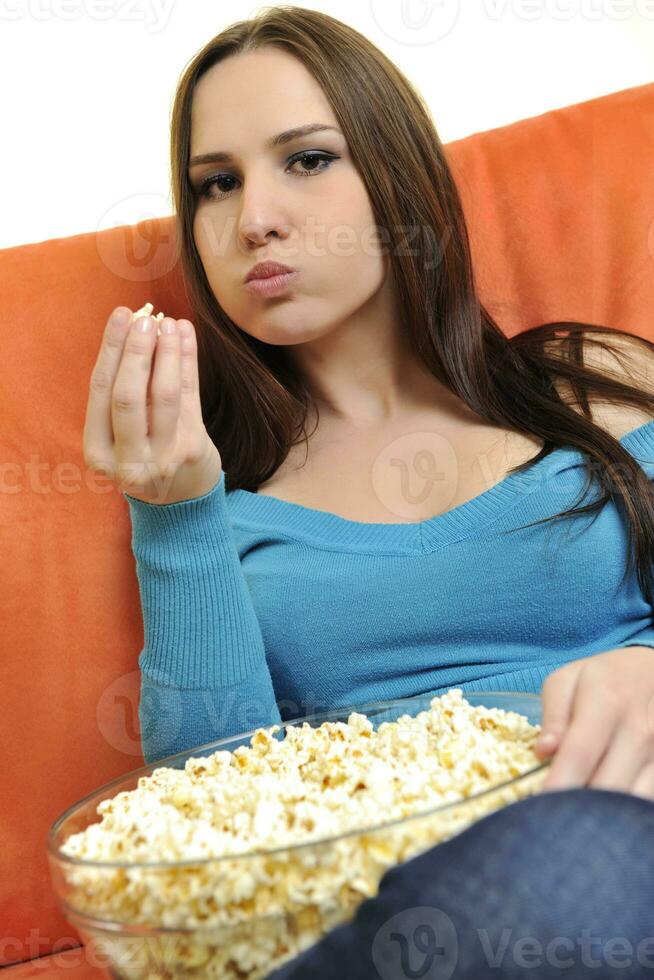 jovem come pipoca e assistindo tv foto