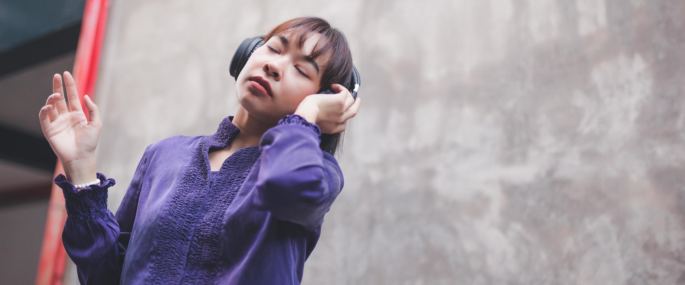 jovem asiática feliz ouvindo música com fones de ouvido foto