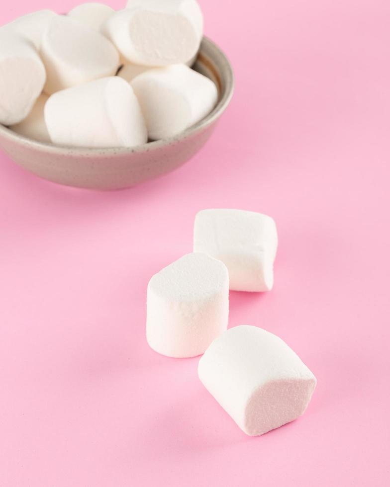 marshmallow em uma tigela em fundo rosa pastel foto