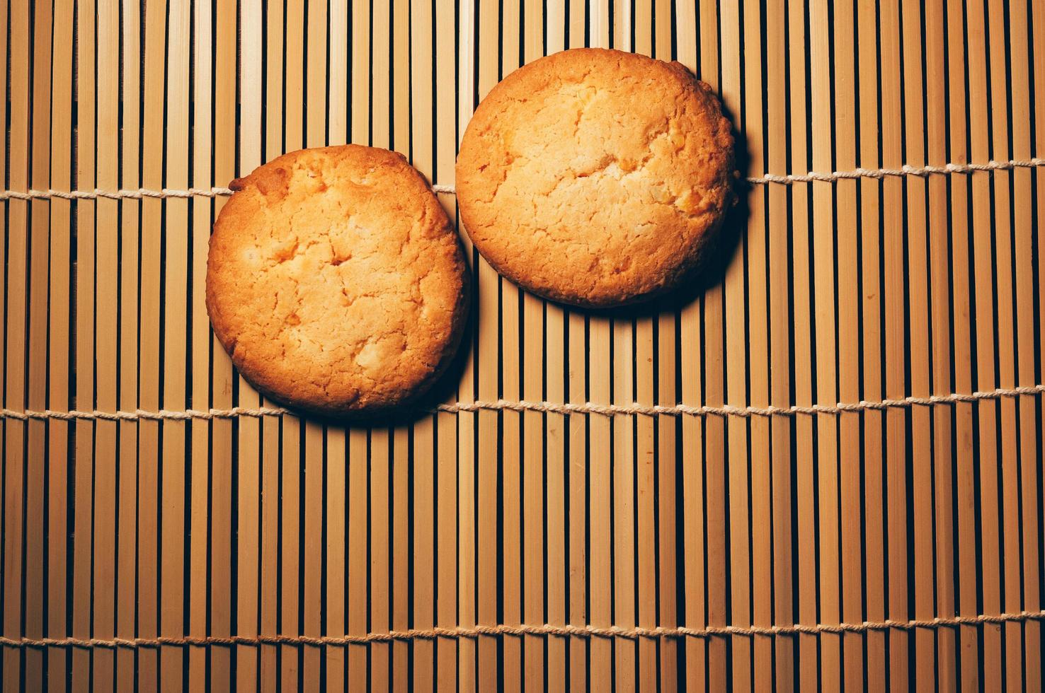 dois biscoitos crocantes redondos, em bambu texturizado, design simples foto