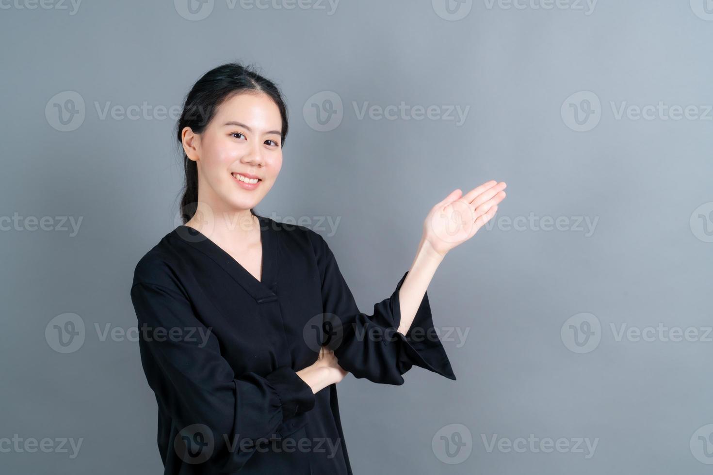 mulher asiática com mão apresentando-se de lado foto
