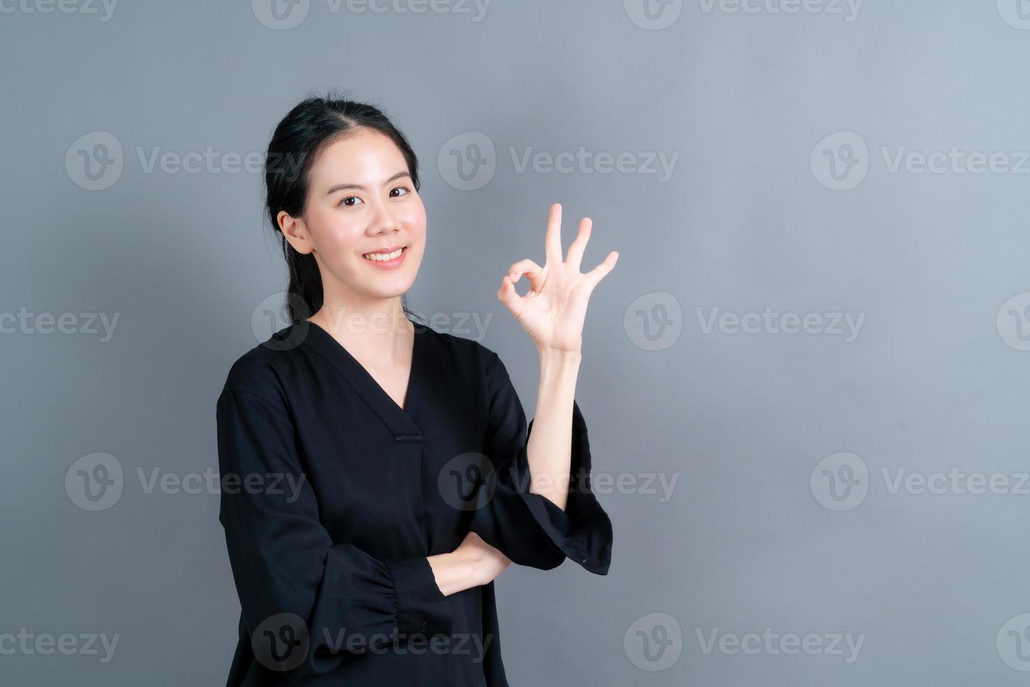 jovem mulher asiática sorrindo e mostrando sinal de ok foto