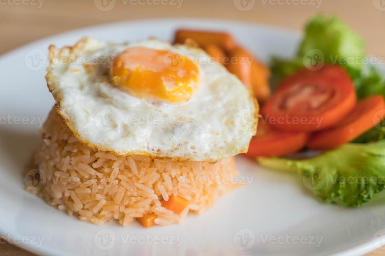 arroz frito com linguiça e ovo frito na mesa foto