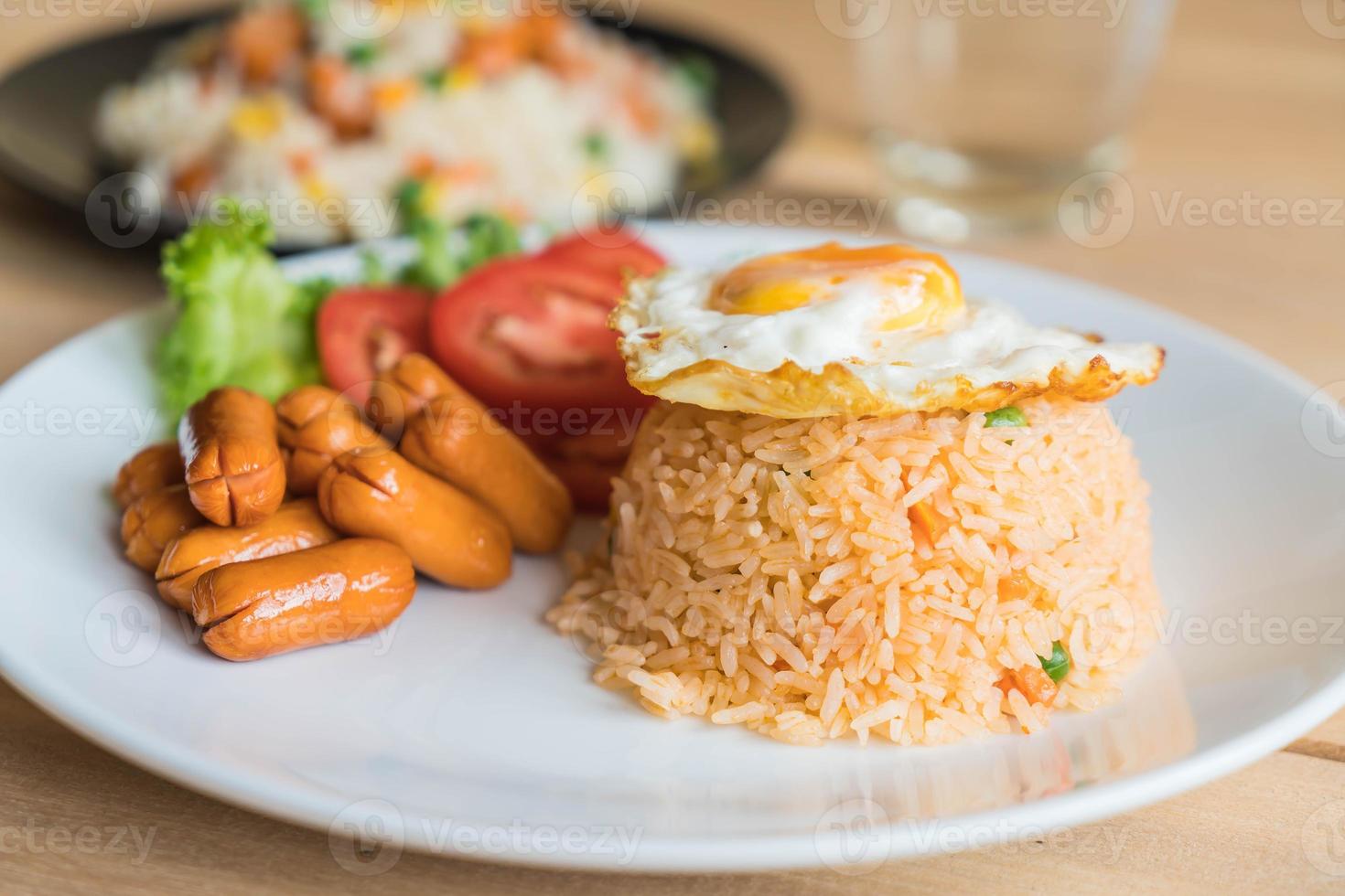 arroz frito com linguiça e ovo frito na mesa foto