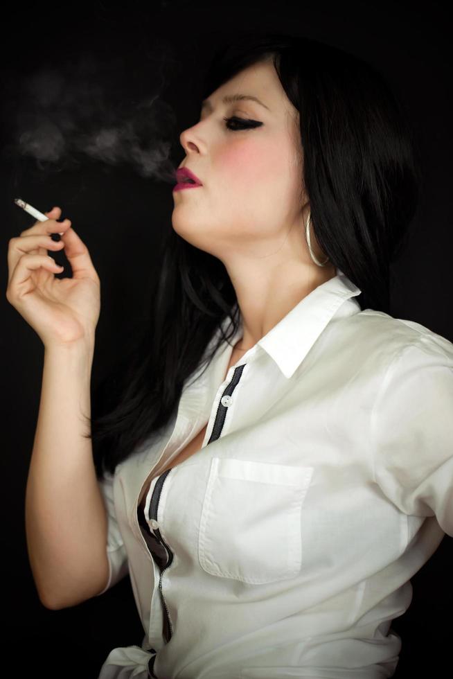 jovem linda mulher fumando cigarro foto