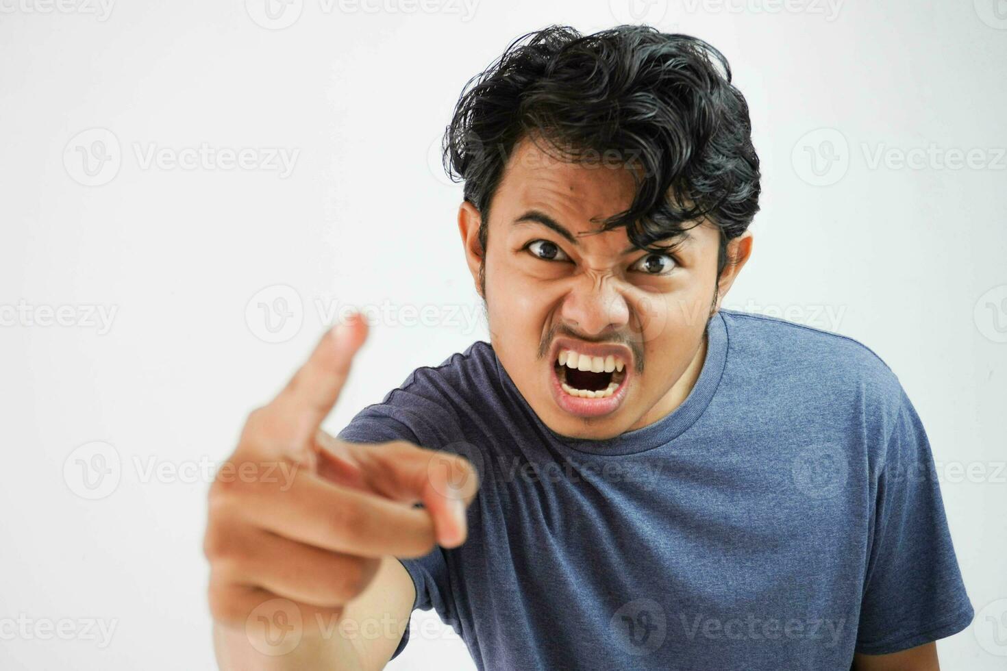 Bravo agressivo jovem ásia homem vestindo t camisa marinha cor gritando Fora alto com feroz expressão e ponto com uma dedo frustrado foto