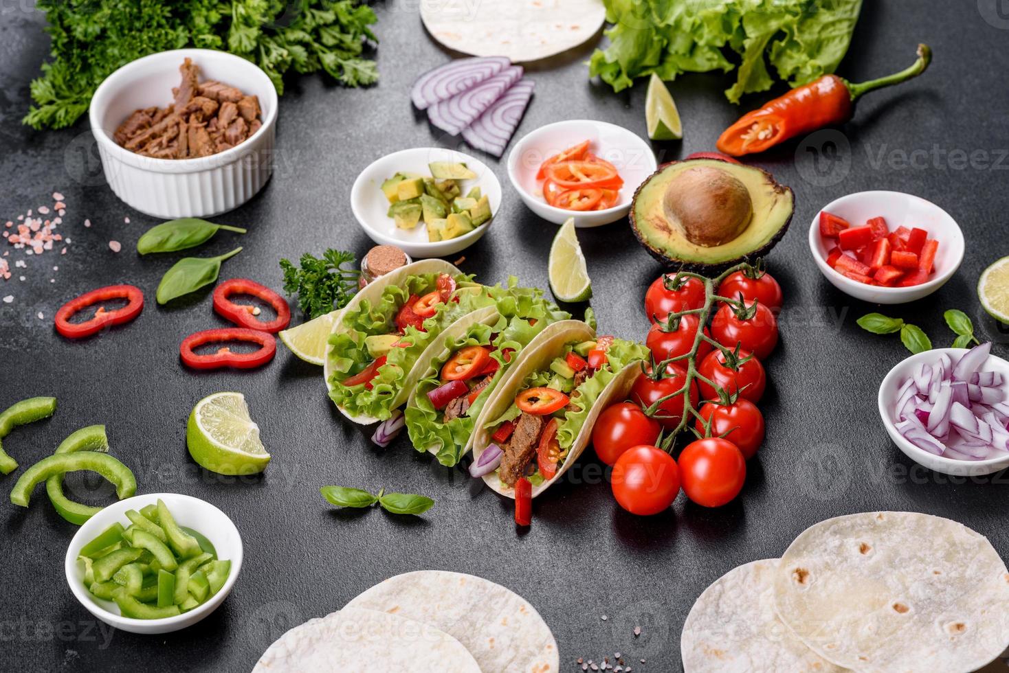 tacos mexicanos com carne, tomate, abacate, cebola e molho de salsa foto