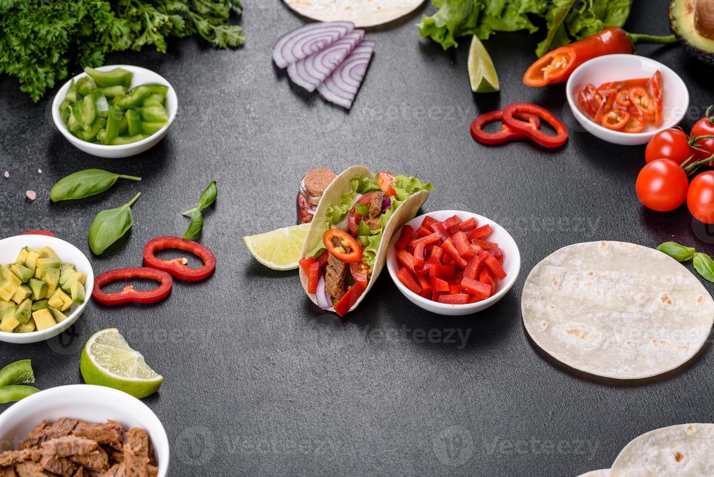 tacos mexicanos com carne, tomate, abacate, cebola e molho de salsa foto