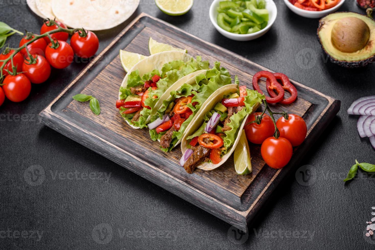 tacos mexicanos com carne, tomate, abacate, cebola e molho de salsa foto