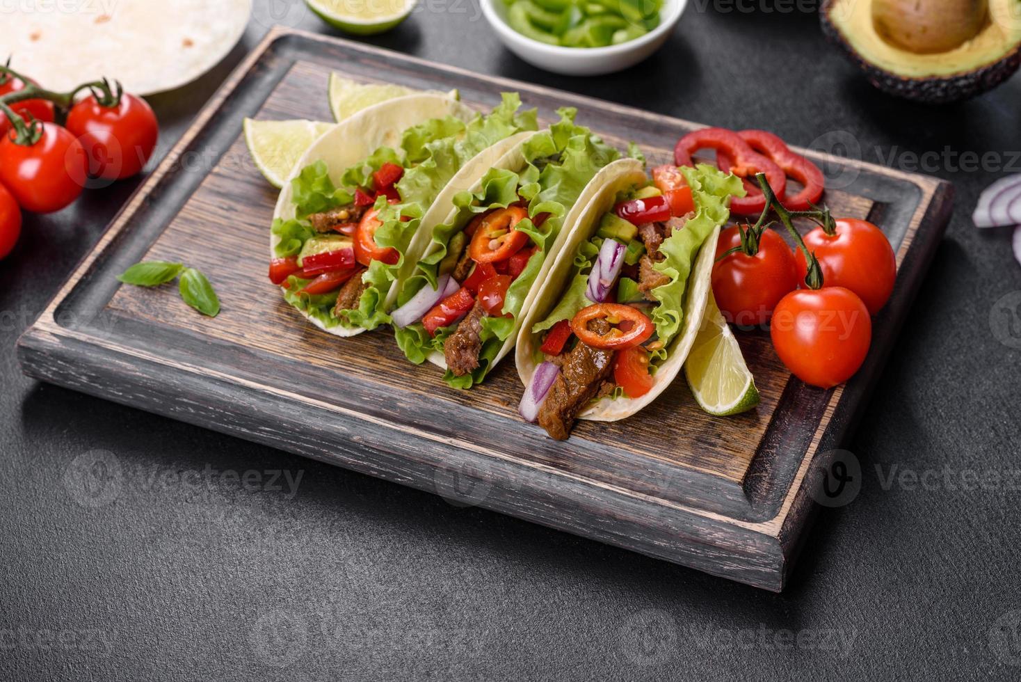 tacos mexicanos com carne, tomate, abacate, cebola e molho de salsa foto