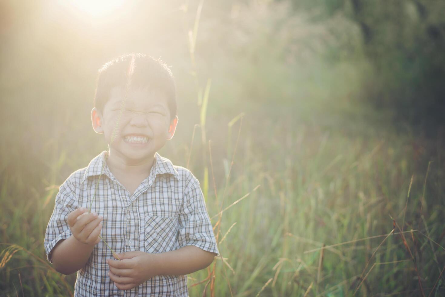 menino asiático feliz brincando ao ar livre. bonito asiático. menino em campo. foto