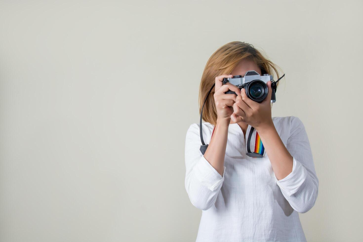 bela jovem fotógrafa segurando uma câmera retro foto