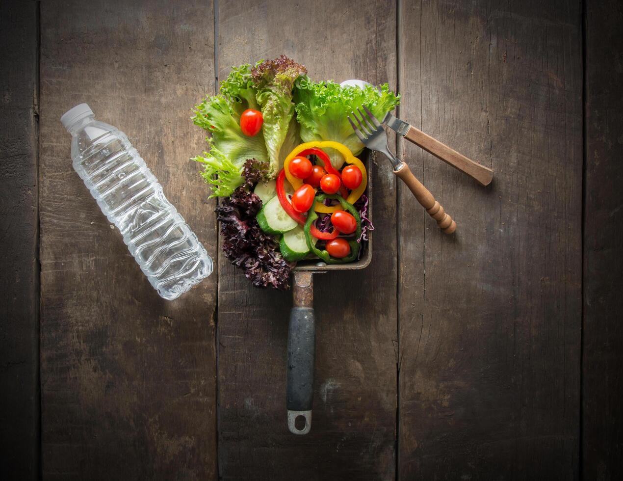 a vista de cima da salada vegetariana é o café da manhã para uma garrafa de água e saudável. foto