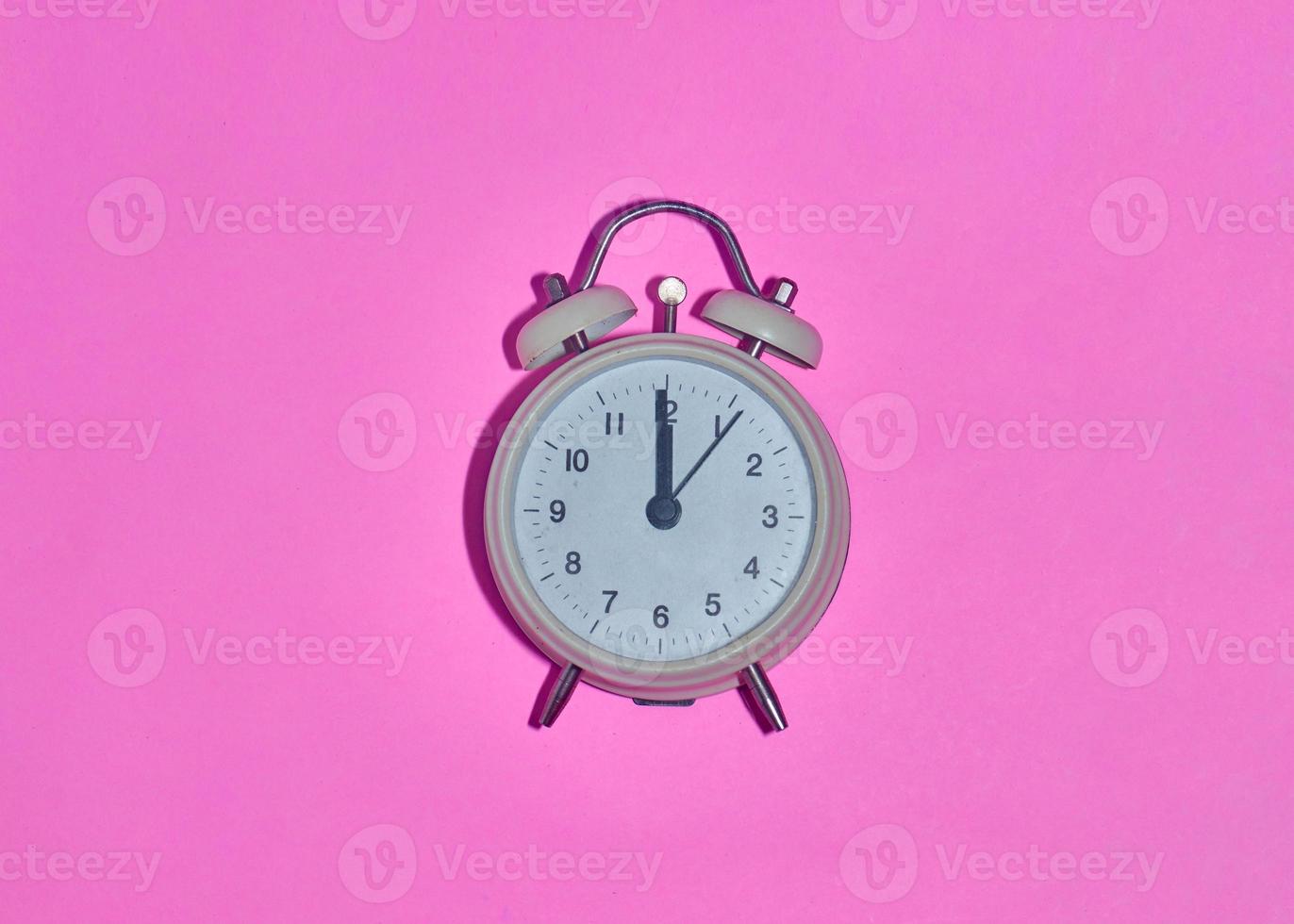 despertador vintage em fundo rosa claro foto