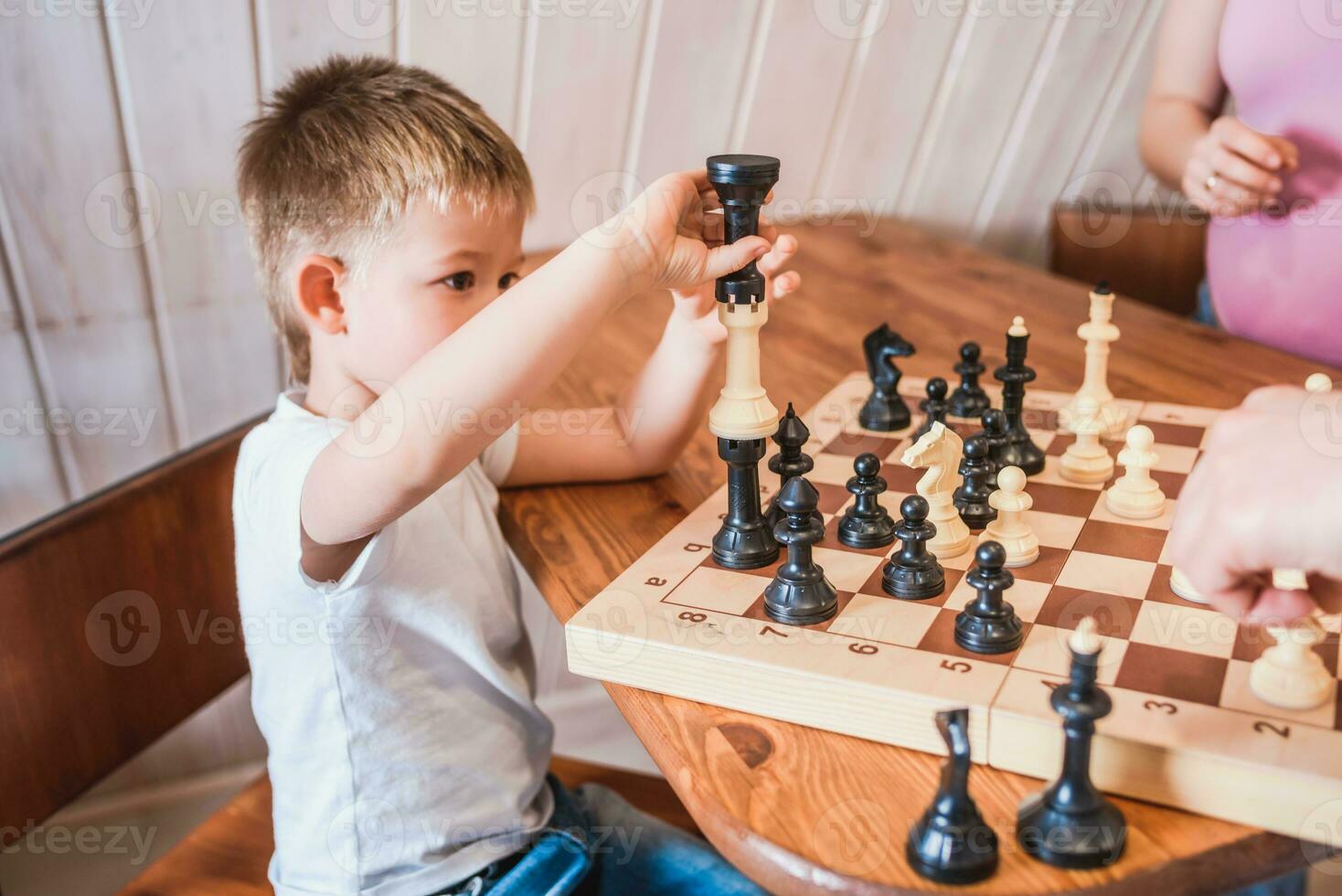 pequeno Garoto jogando xadrez às casa às a mesa foto