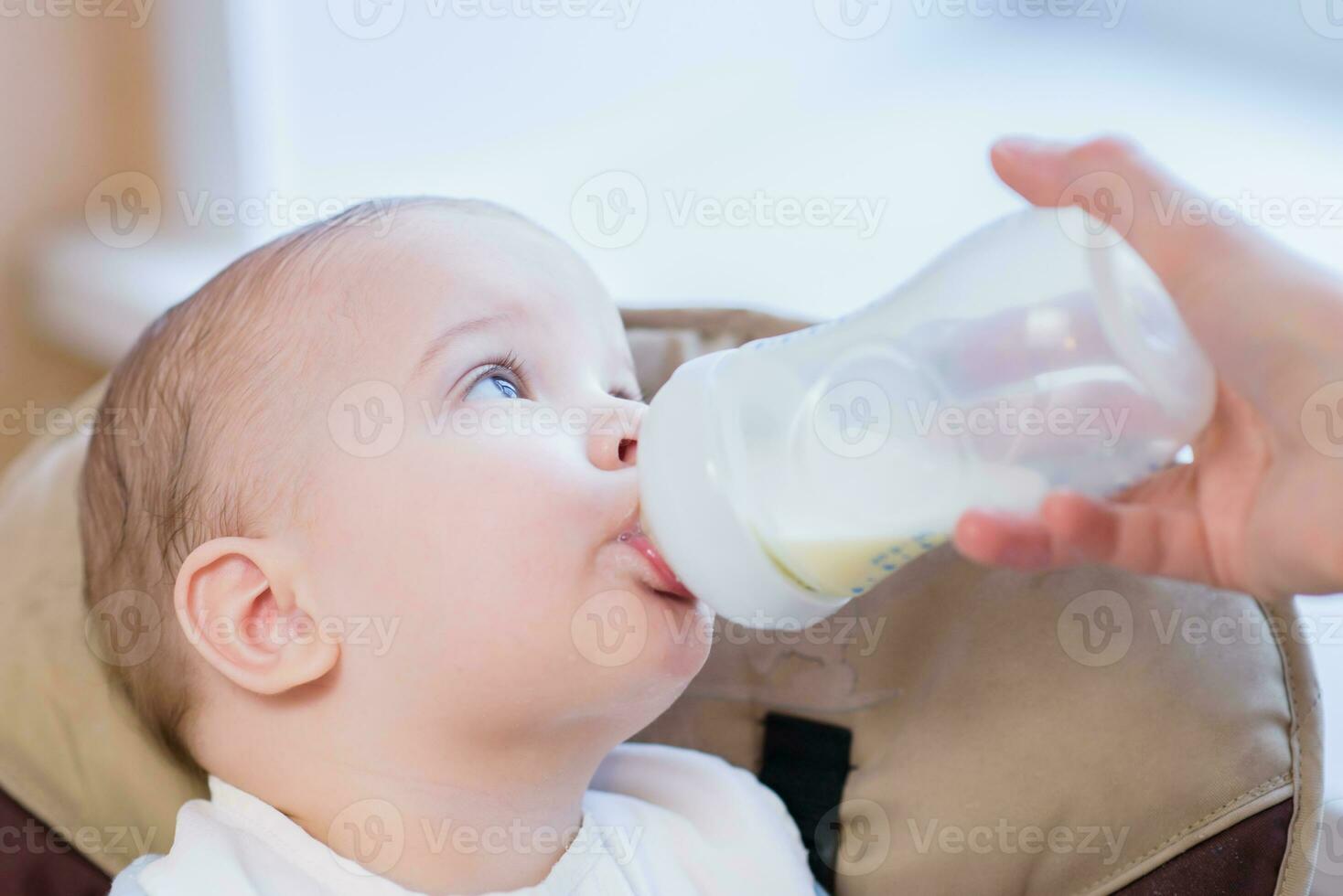 mãe feeds bebê a partir de uma garrafa do leite foto