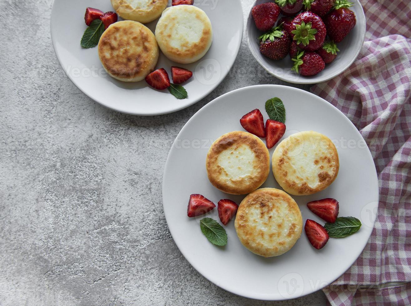 panquecas de queijo cottage na placa de cerâmica com morango fresco. foto