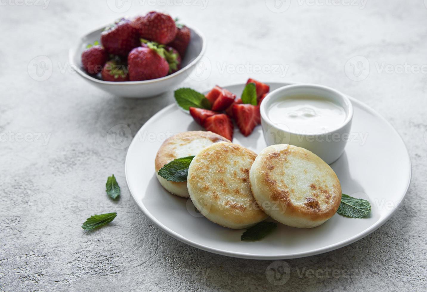 panquecas de queijo cottage na placa de cerâmica com morango fresco. foto