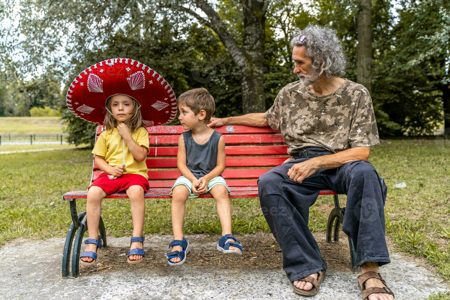 retrato do pai com dois filhos em período de férias ao ar livre sentado em uma metal Banco foto