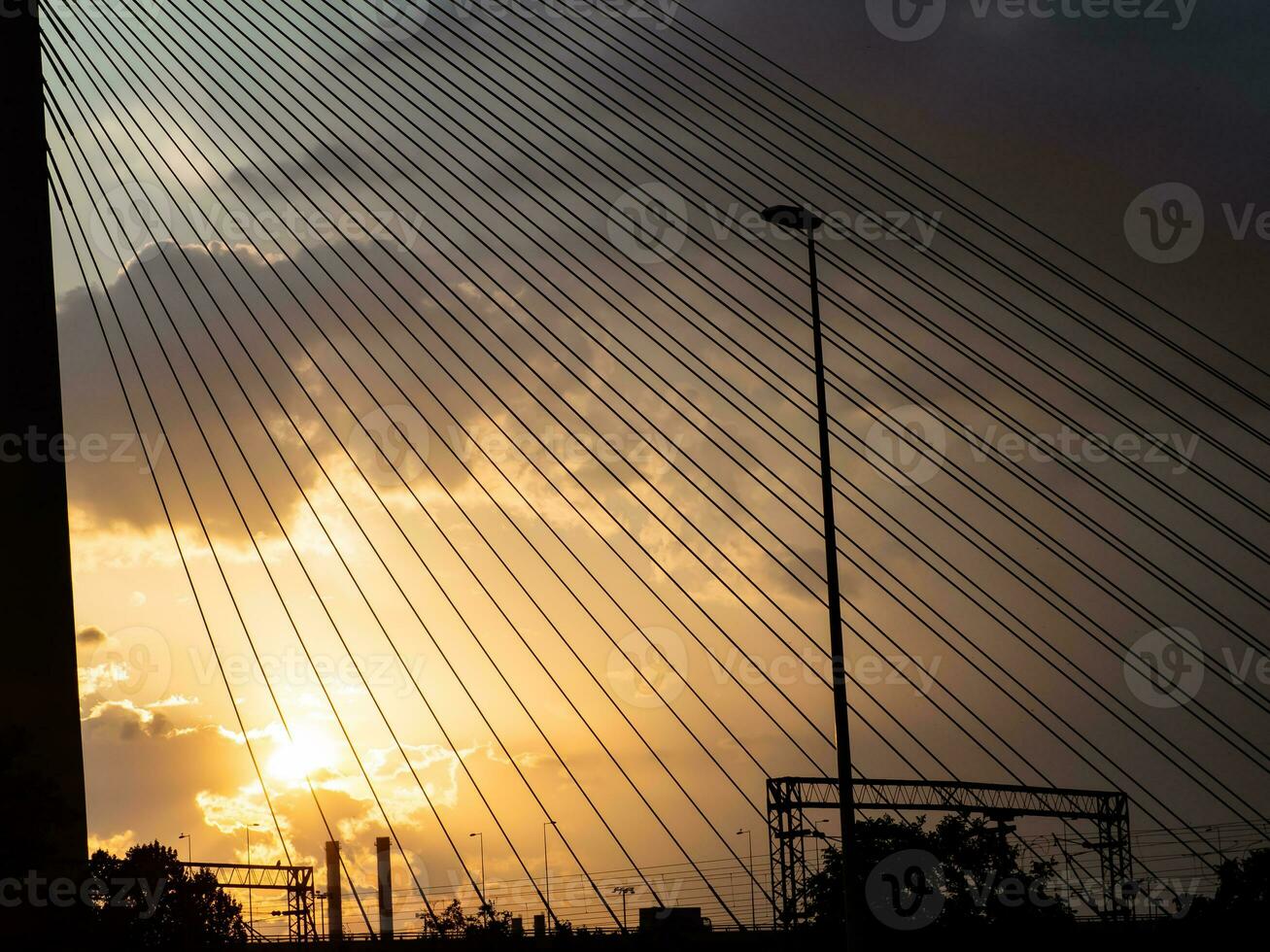 pôr do sol através a suspensão cabos com industrial chaminés dentro a fundo foto