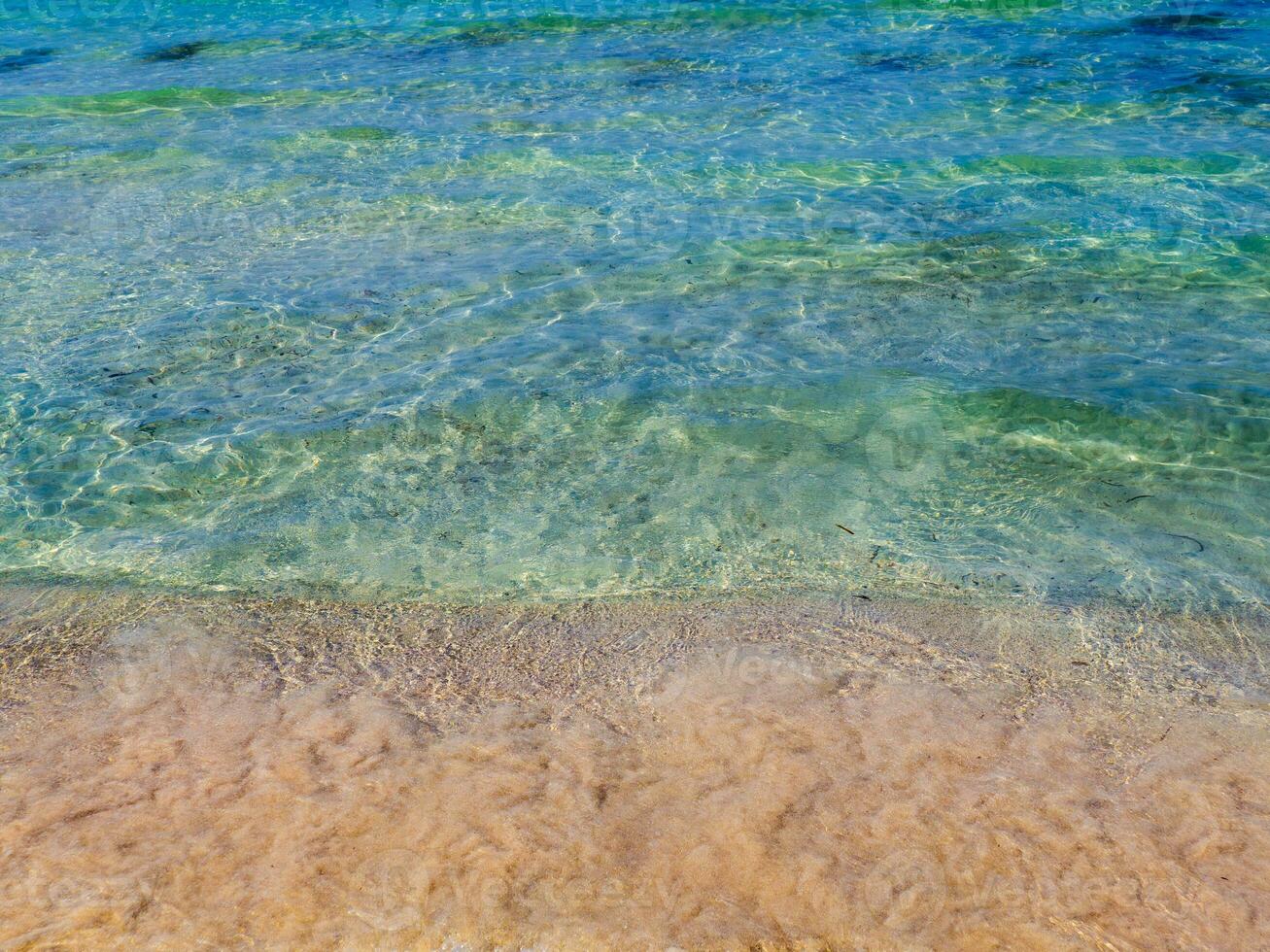 surpreendente Claro azul água e limpar \ limpo arenoso de praia foto