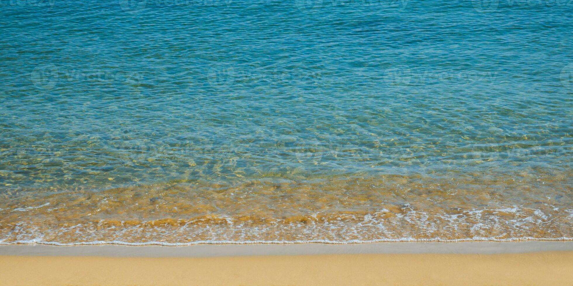 molusco e lindo esvaziar de praia - surpreendente azul Claro mar água e laranja areia foto