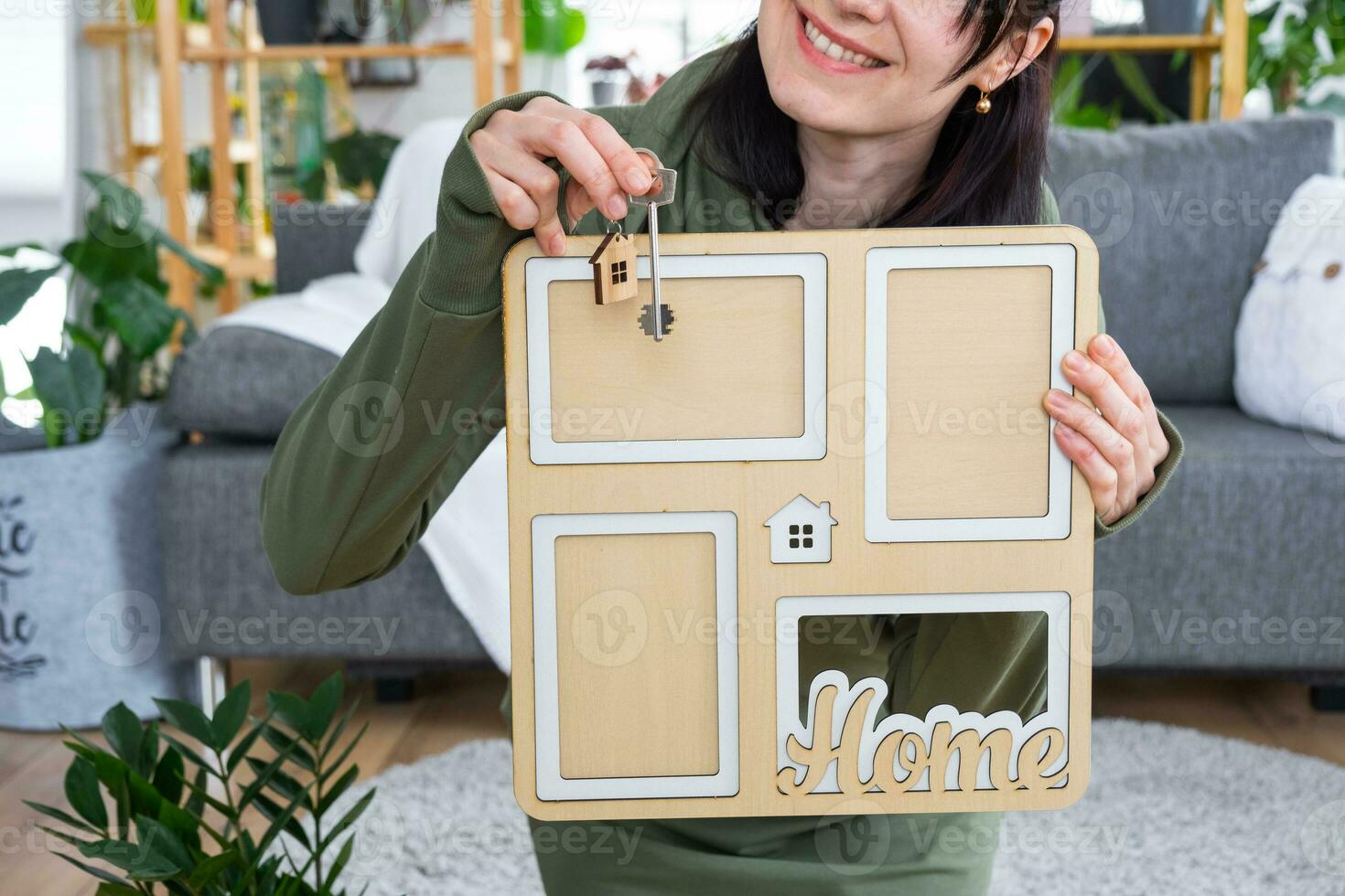 feliz mulher dentro casa detém dentro mãos foto quadro, Armação com figura às casa modelo e chave dentro interior. Sonhe casa projeto, real Estado comprar, seguro, hipoteca, aluguel, reserva