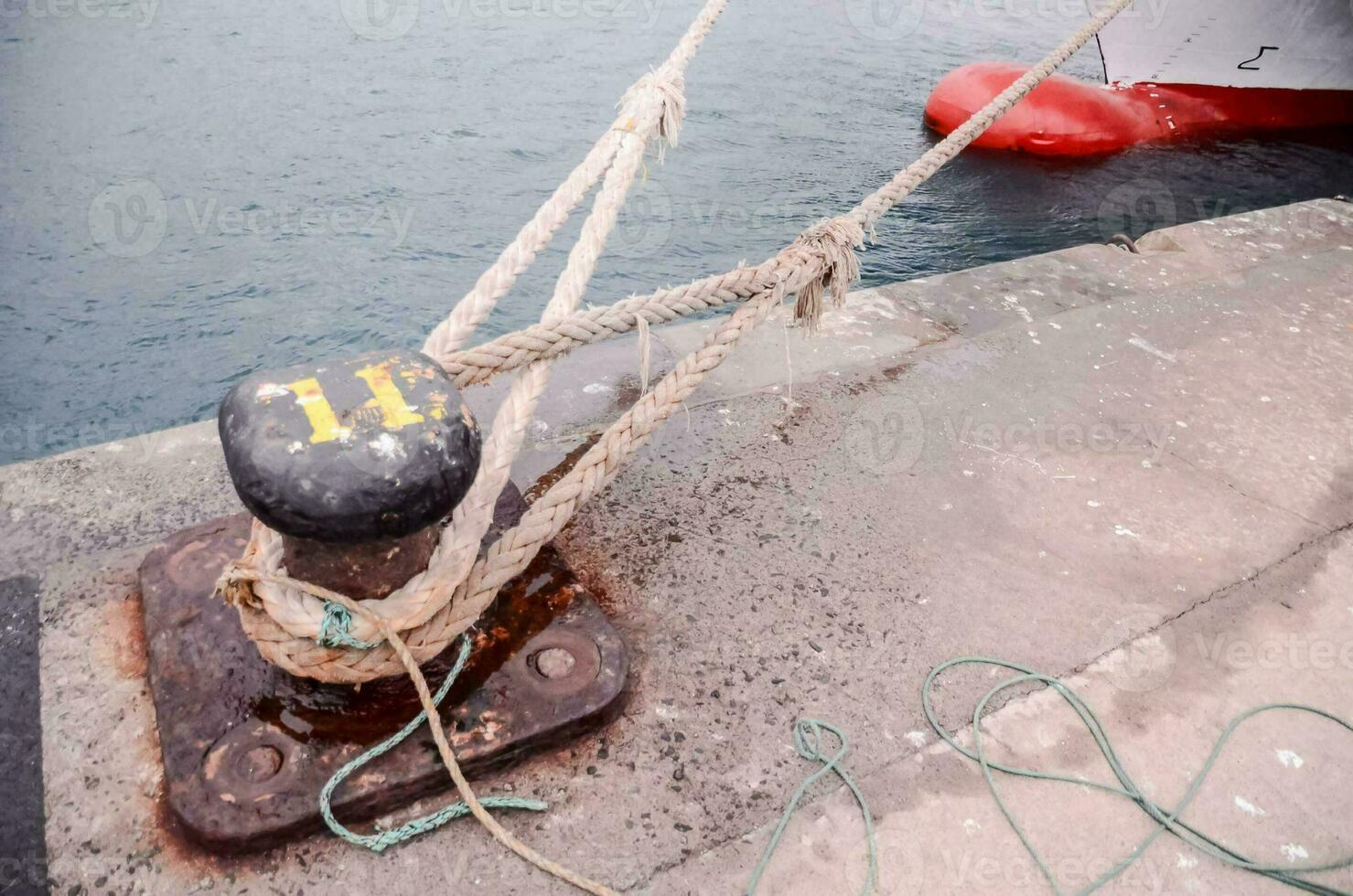 uma corda amarrado para uma metal postar perto uma barco foto