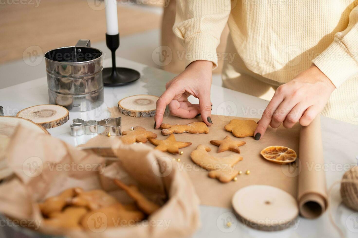 uma mulher mãos mudança gengibre biscoitos a partir de papel para uma caixa foto