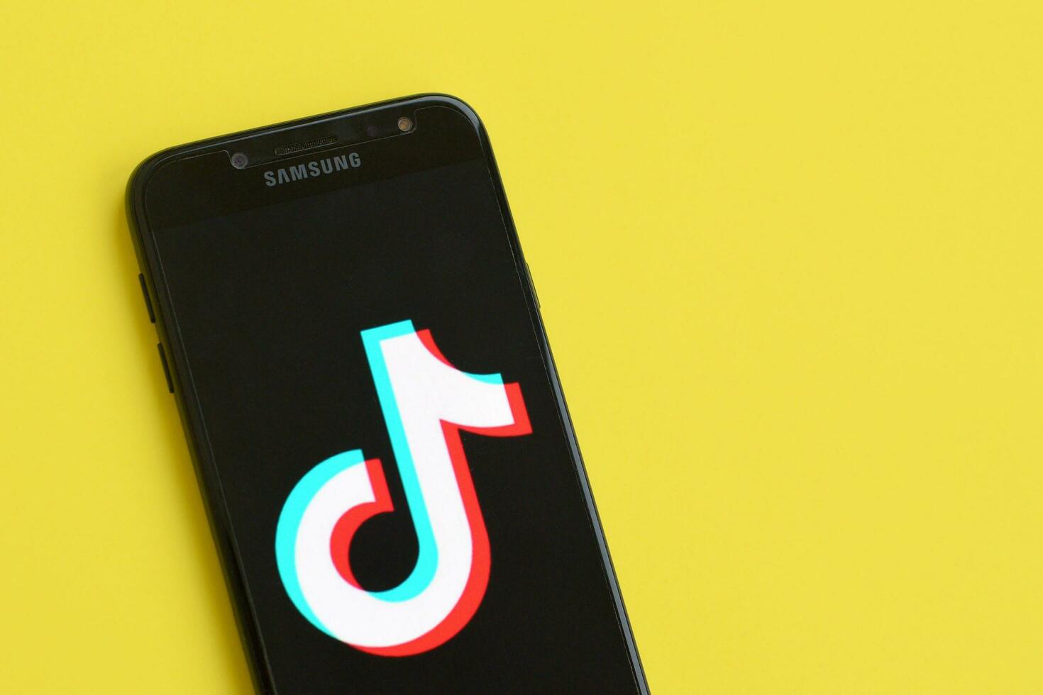 tiktok logotipo em samsung Smartphone tela em amarelo fundo. tiktok é uma popular compartilhamento de vídeo social trabalho em rede serviço possuído de bytedance foto