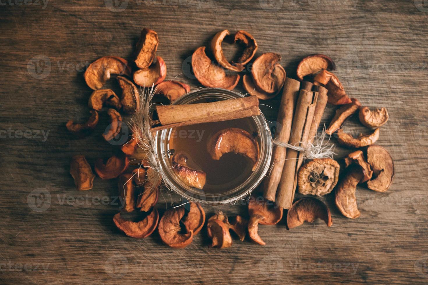 compota de frutas de maçãs secas em uma jarra de vidro em uma placa de madeira rusric foto