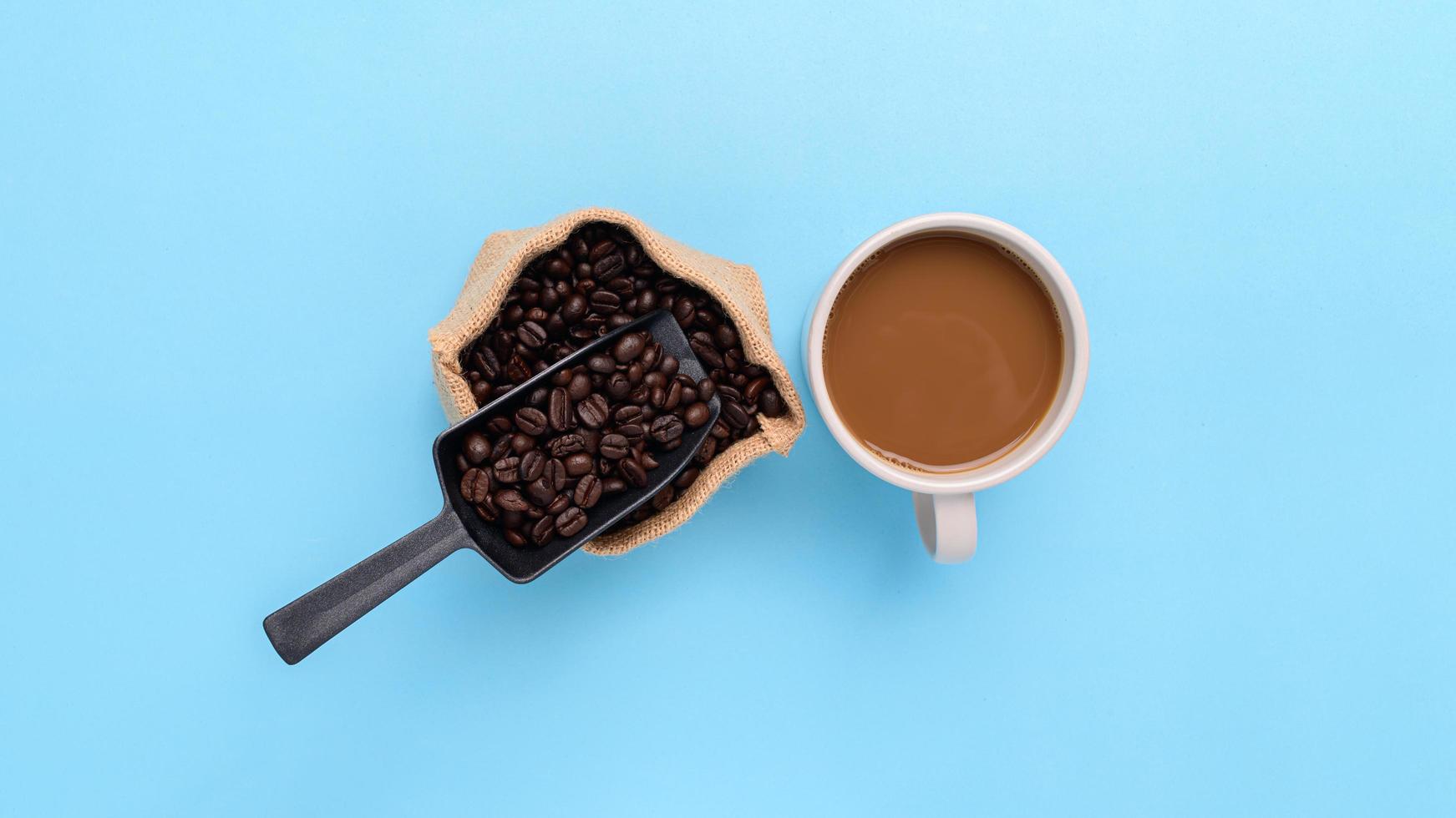 caneca de café, grãos de café, café moído em um fundo azul foto