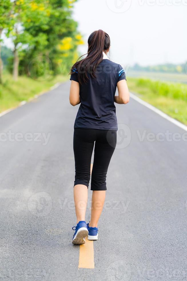 garota de esportes, mulher correndo na estrada, treinamento de mulher saudável foto